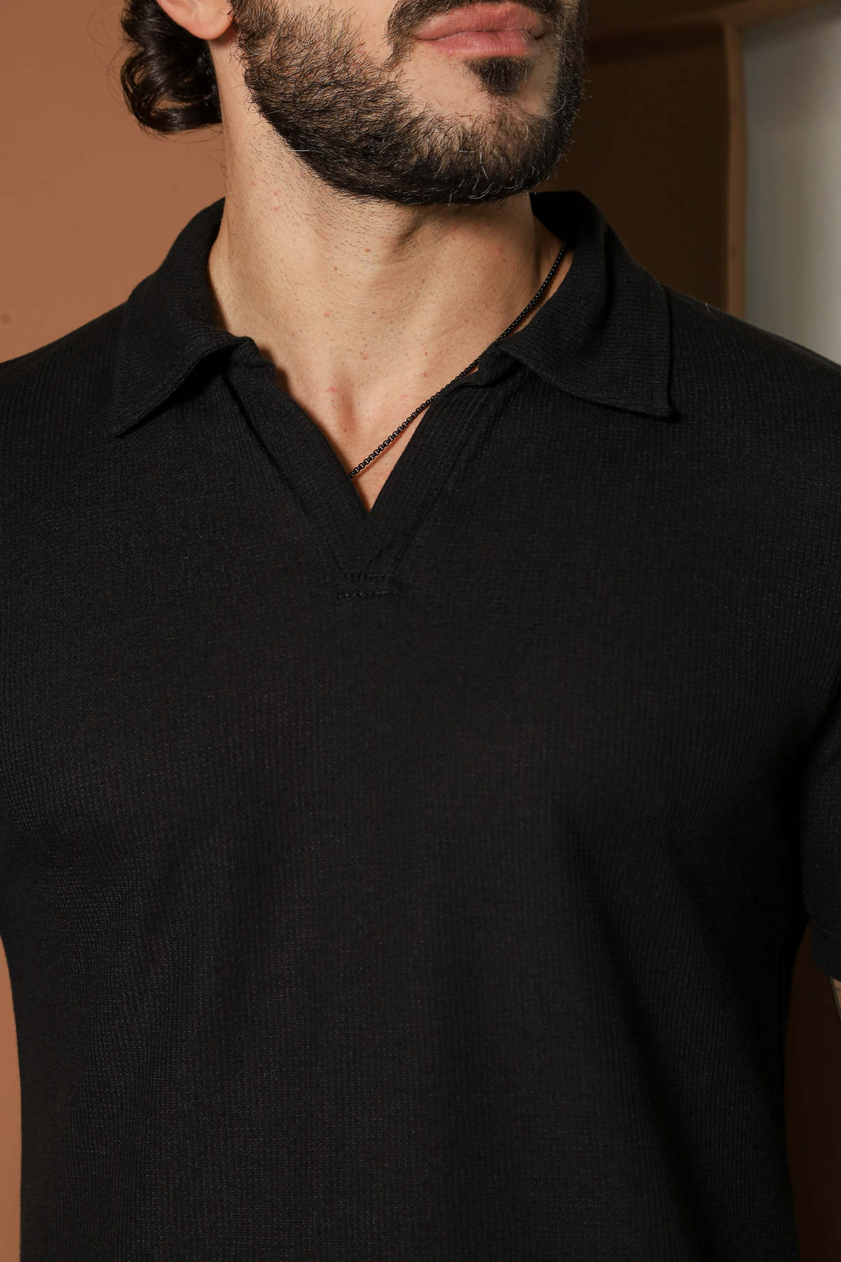 Camisa polo masculina preta tricot texturizada da Harpia Moda Masculina, vista frontal com detalhes do tecido.